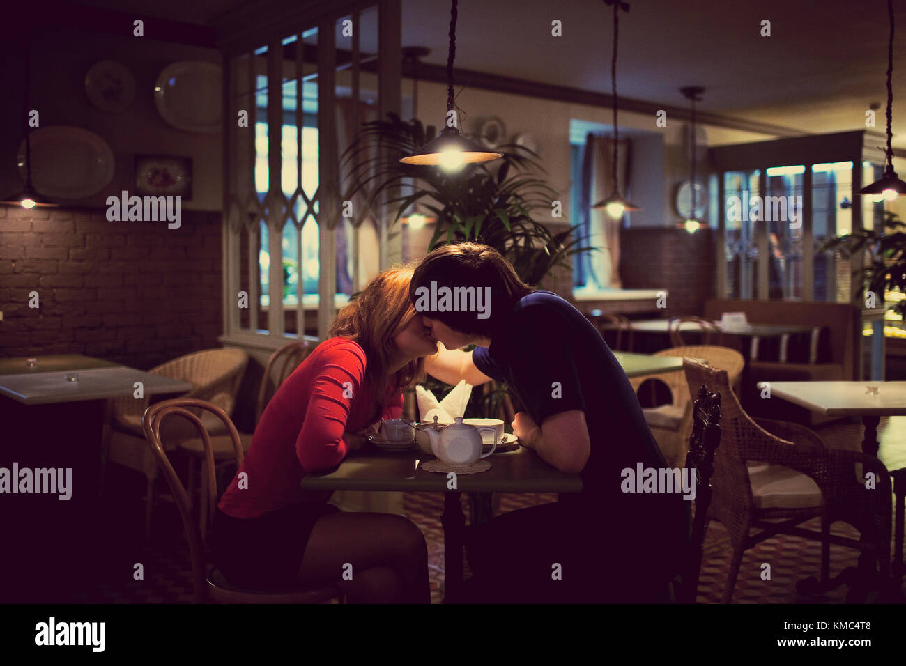 La jeune fille avec le gars baiser dans cafe. atmosphère romantique. Banque D'Images