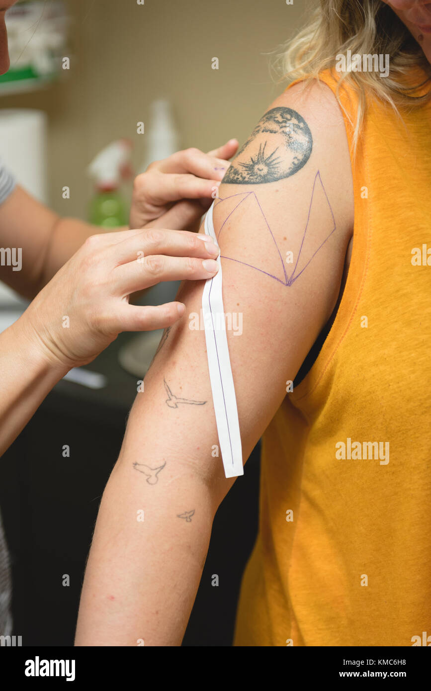L'artiste tattoo professionnel fait un tatouage à la main des womans Banque D'Images