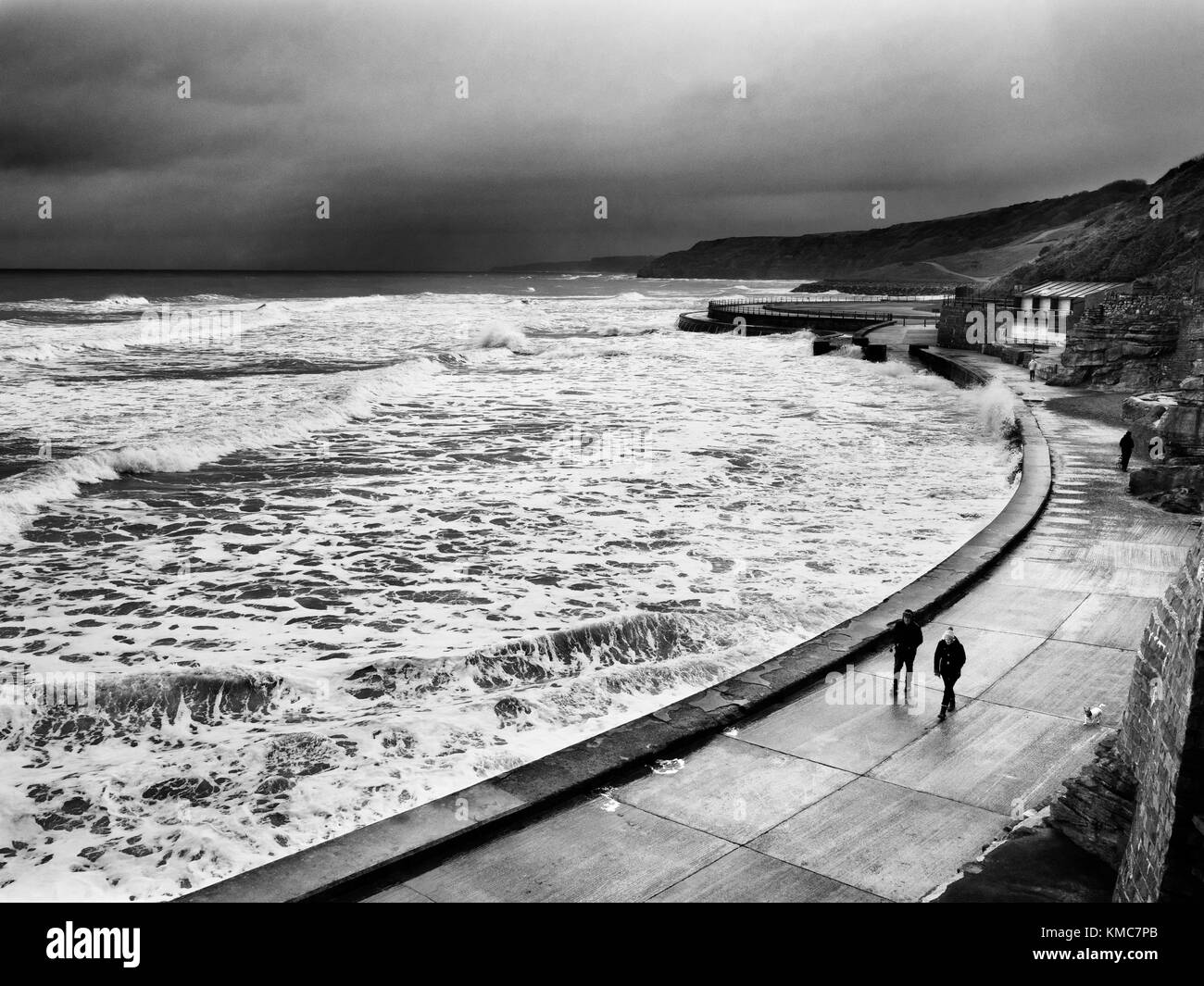 Les gens à pied par la Digue par mauvais temps à marée haute dans la région de South Bay à Scarborough North Yorkshire Angleterre Banque D'Images