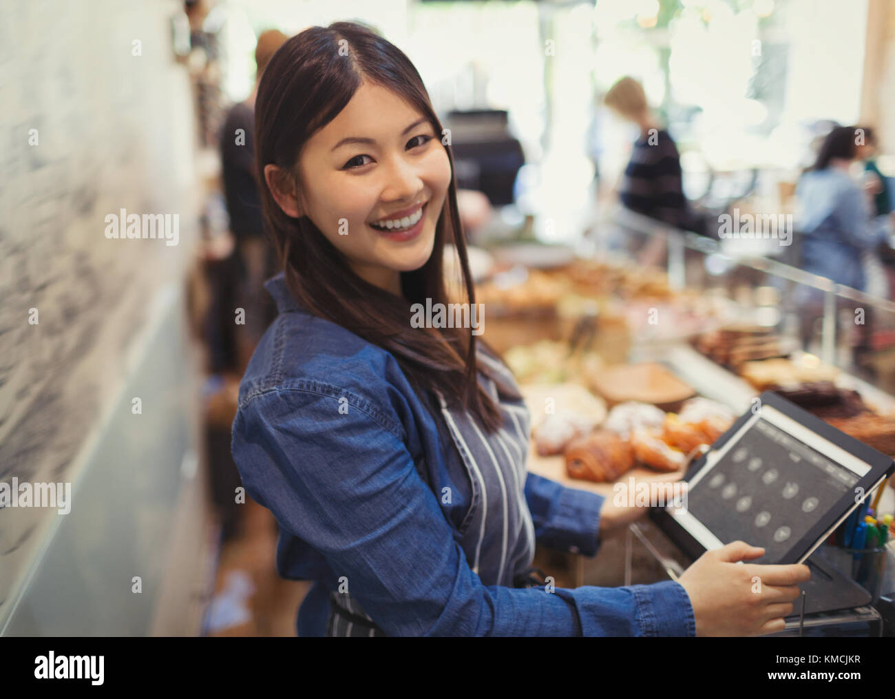 Portrait souriant, femme confiante à la caisse du café Banque D'Images