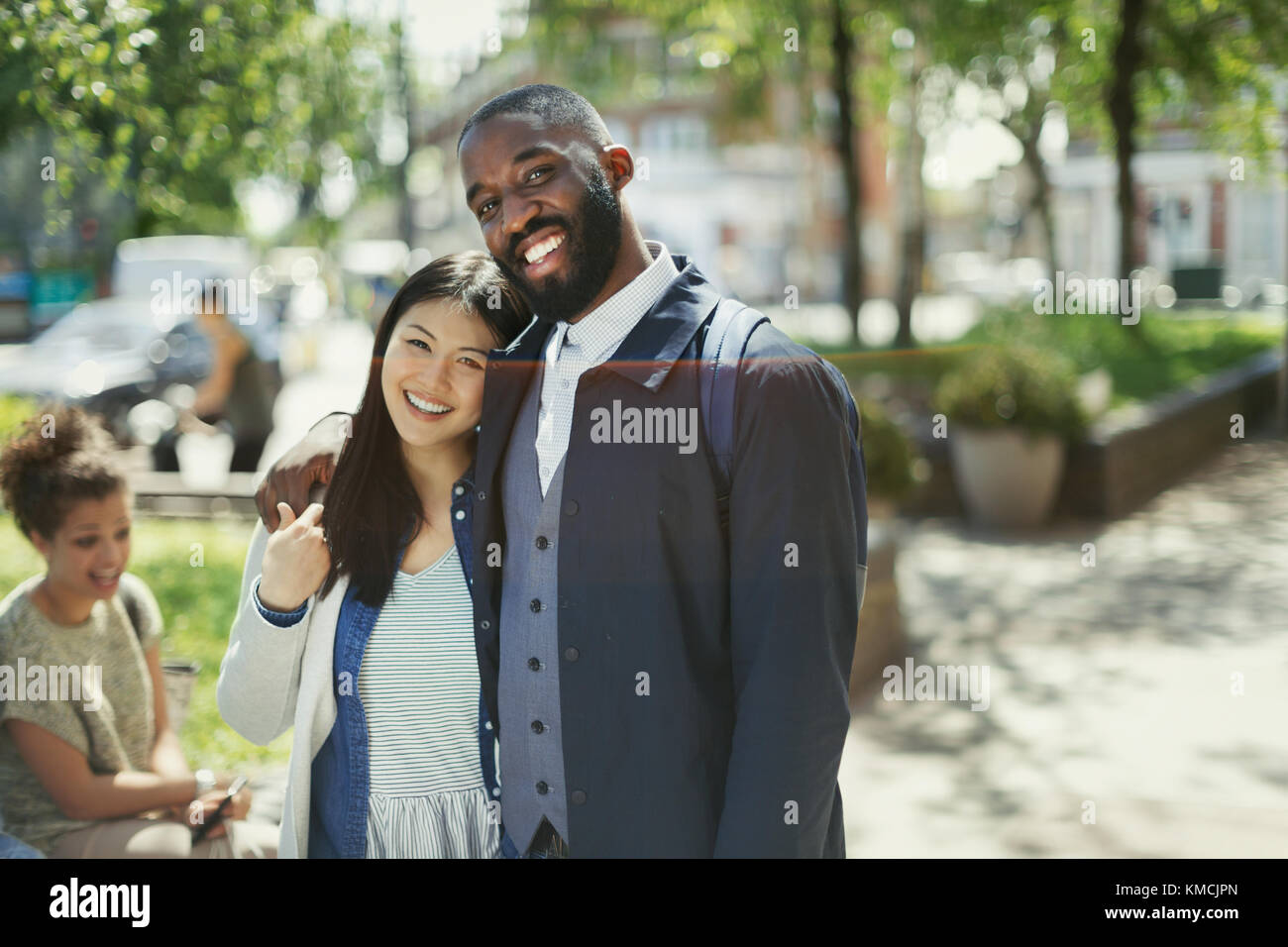 Portrait souriant, affectueux jeune couple qui s'embrasse dans un parc ensoleillé Banque D'Images