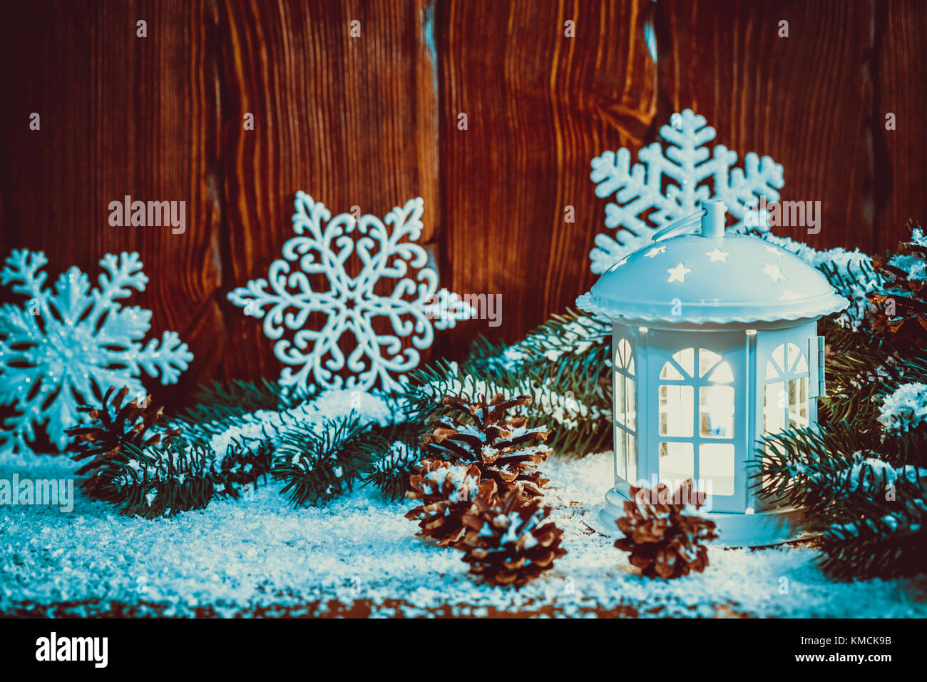Noël lanterne avec éclairée par des bougies, des branches d'arbre de Noël, des cônes, des flocons de neige et sur fond de bois vintage. Espace libre Banque D'Images Noël lanterne avec éclairée par des bougies, des branches d'arbre de Noël, des cônes, des flocons de neige et sur fond de bois vintage. Espace libre Banque D'Images