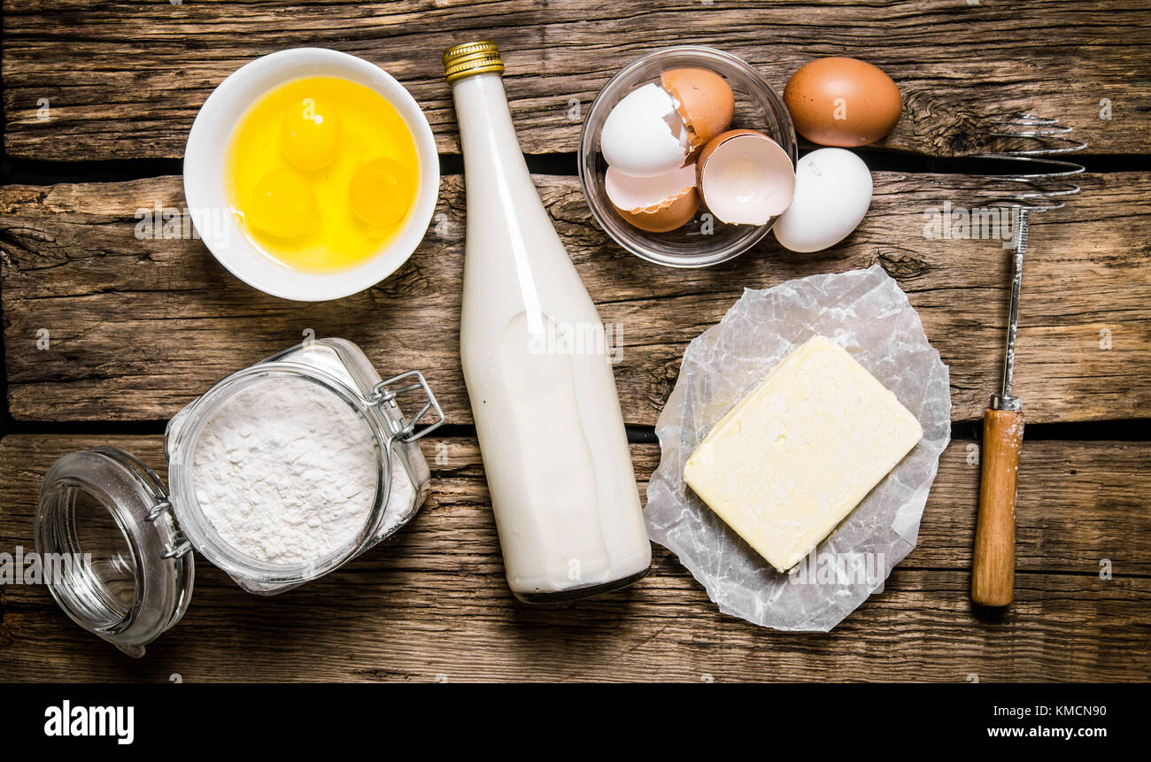 Préparation de la pâte. Ingrédients pour la pâte - lait, oeufs, beurre,  farine et fouetter. sur une table en bois. Vue de dessus Photo Stock - Alamy