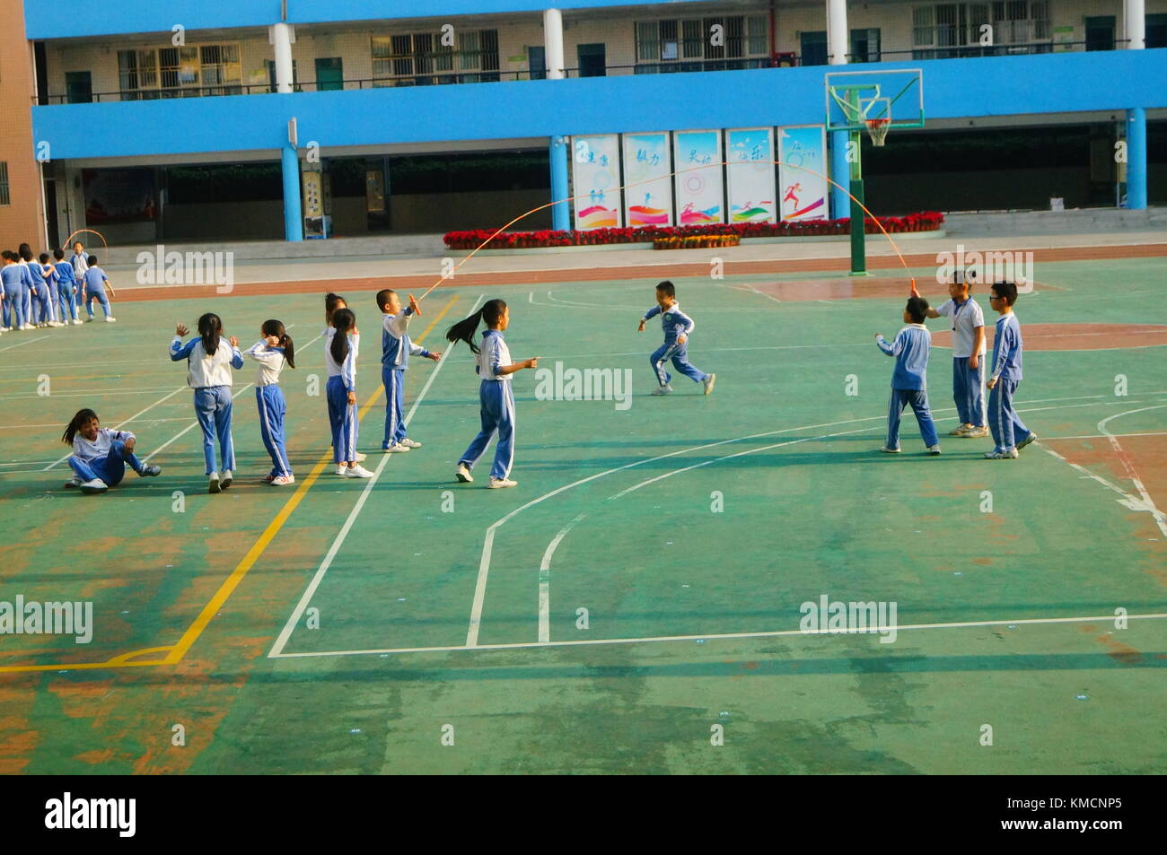 Dans la cour de l'école primaire, les élèves du primaire sont en cours de sport et corde à sauter. à Shenzhen, Chine. Banque D'Images