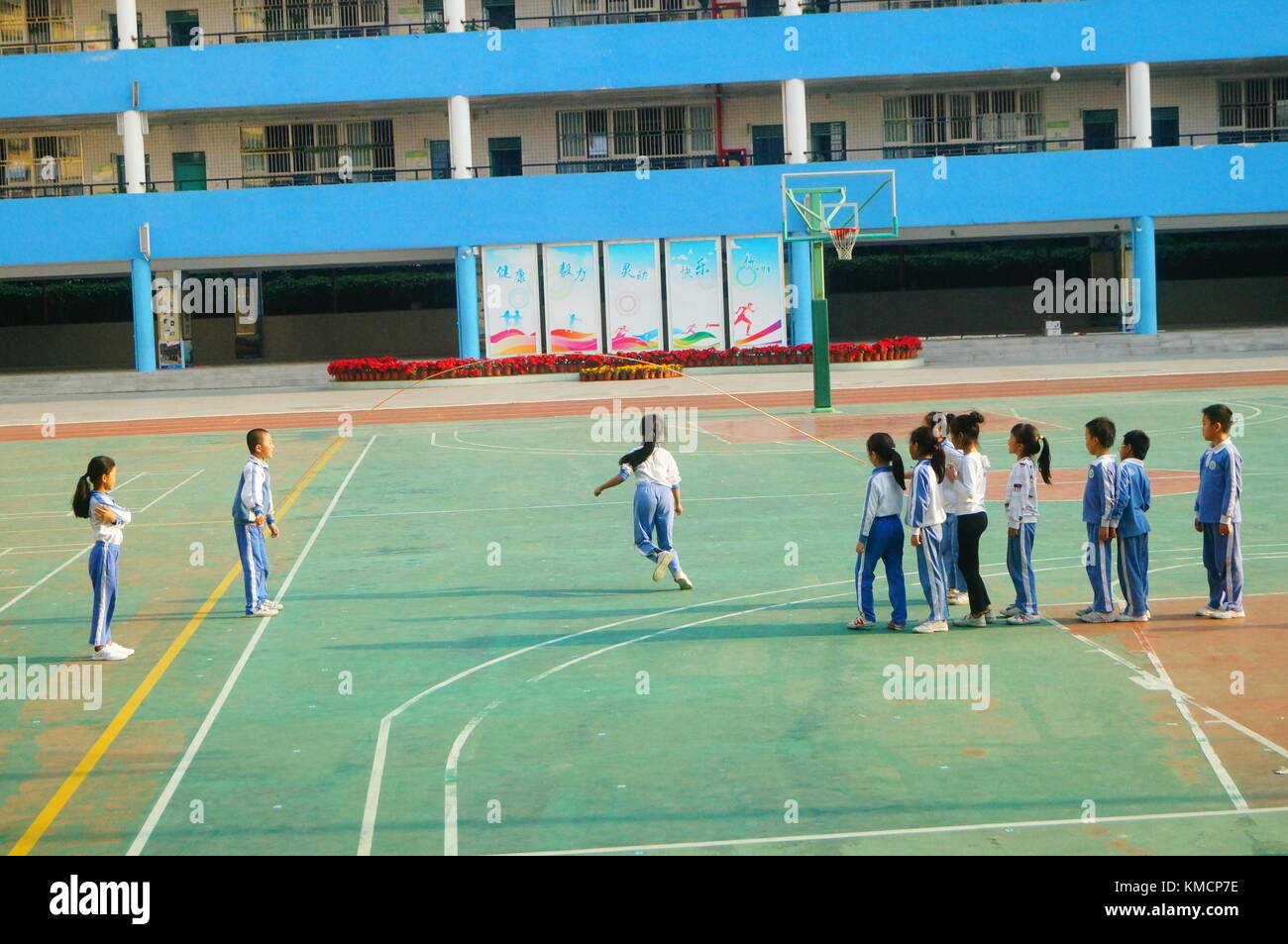 Dans la cour de l'école primaire, les élèves du primaire sont en cours de sport et corde à sauter. à Shenzhen, Chine. Banque D'Images