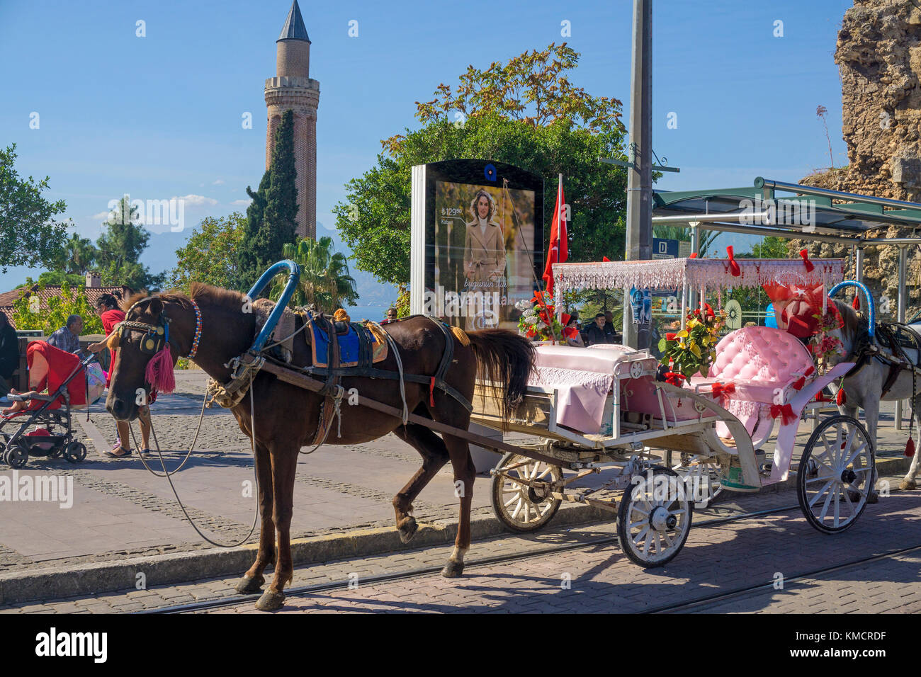 Calèche décorée en attente à la station de tramway, derrière le minaret yivli, kaleici, la vieille ville d'Antalya, Turkish riviera, Turquie Banque D'Images