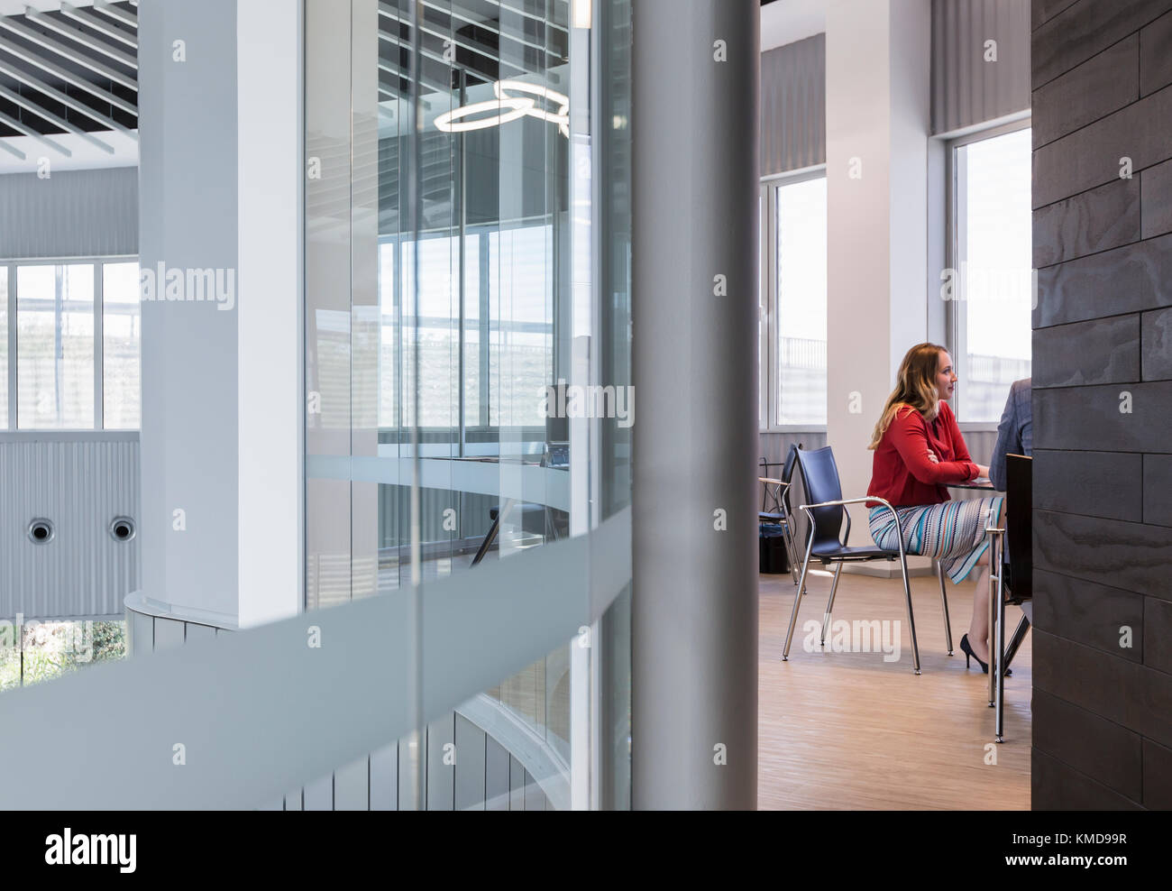 Femme d'affaires à l'écoute dans une salle de conférence moderne Banque D'Images