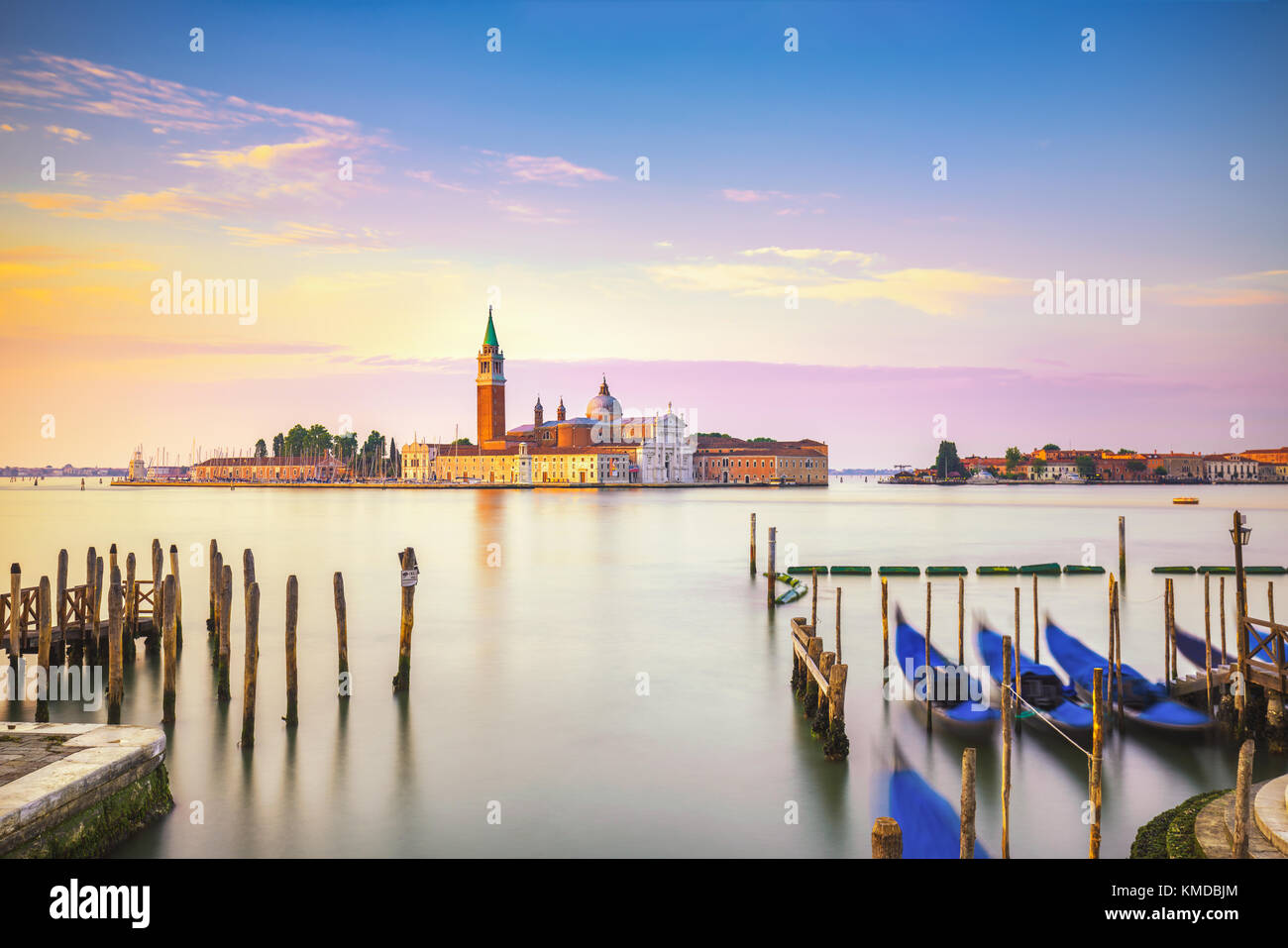 Lagune de Venise au lever du soleil, l'église San Giorgio Maggiore, gondoles et poteaux. L'Italie, l'Europe. Banque D'Images