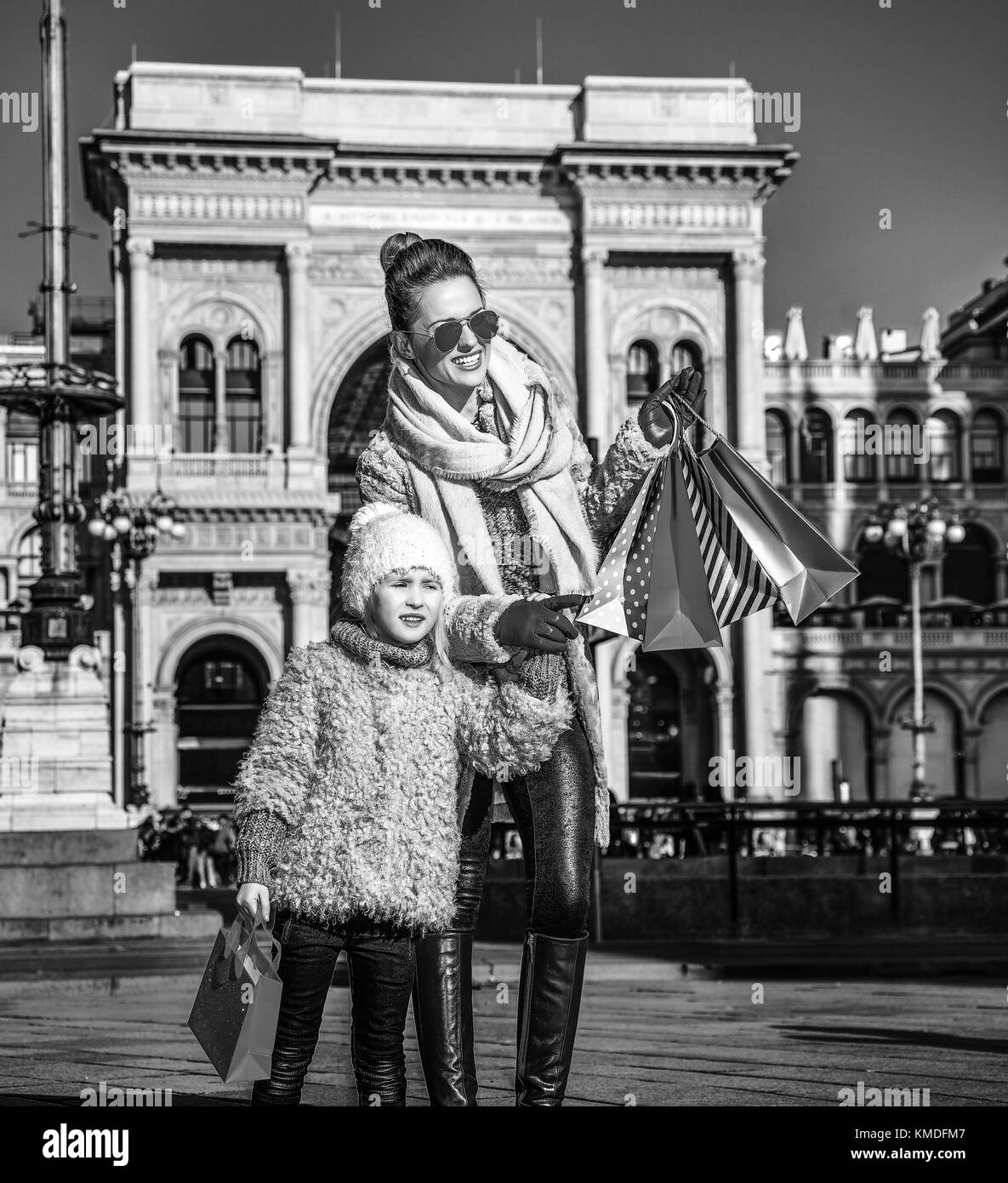 Redécouvrir les choses tout le monde aime à Milan. Full Length portrait of smiling mother and child moderne les voyageurs avec les sacs à Piazza del Duom Banque D'Images