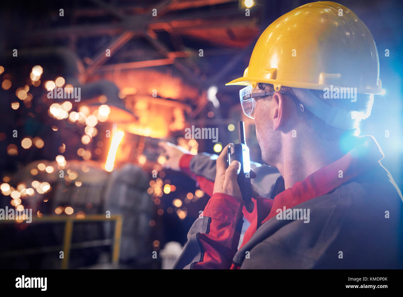 Steelworker parlant, en utilisant walkie-talkie dans l'aciérie Banque D'Images