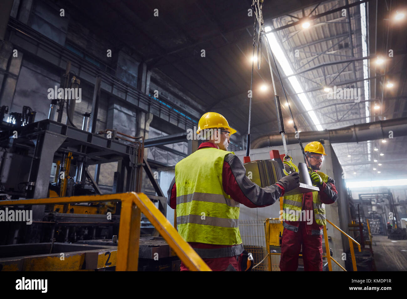 Les Métallurgistes déplacent une pièce d'acier dans une aciérie Banque D'Images