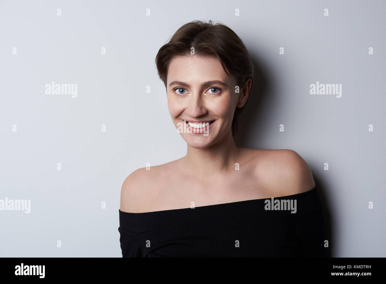 Portrait de femme brune cheveux courts sur fond gris Banque D'Images