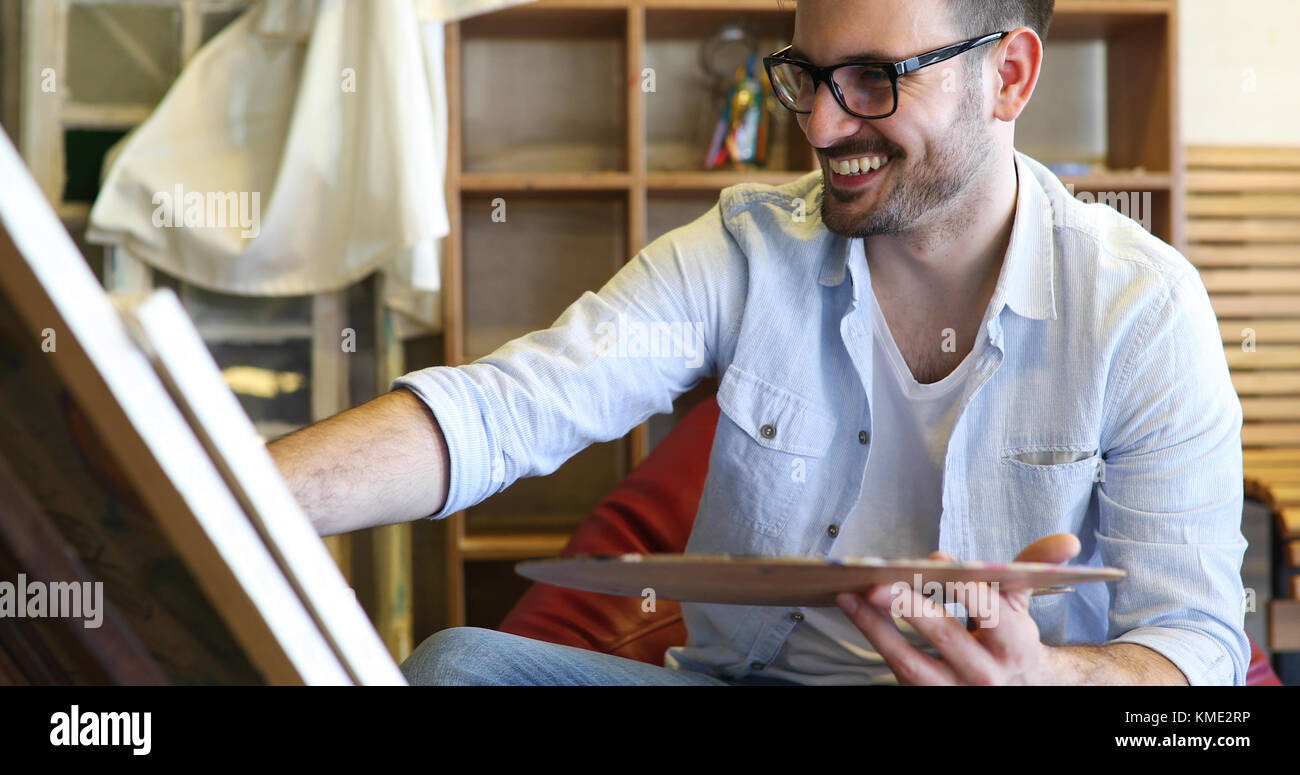 Portrait d'artistes masculins travaillant sur la peinture en studio Banque D'Images