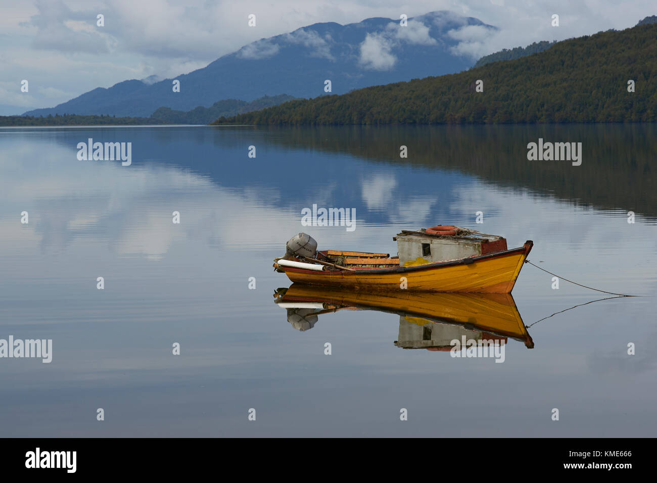 Petit bateau amarré sur les eaux calmes d'un loch de mer à Puyuhuapi, une petite ville sur la Carretera Austral dans le nord de la Patagonie, au Chili. Banque D'Images