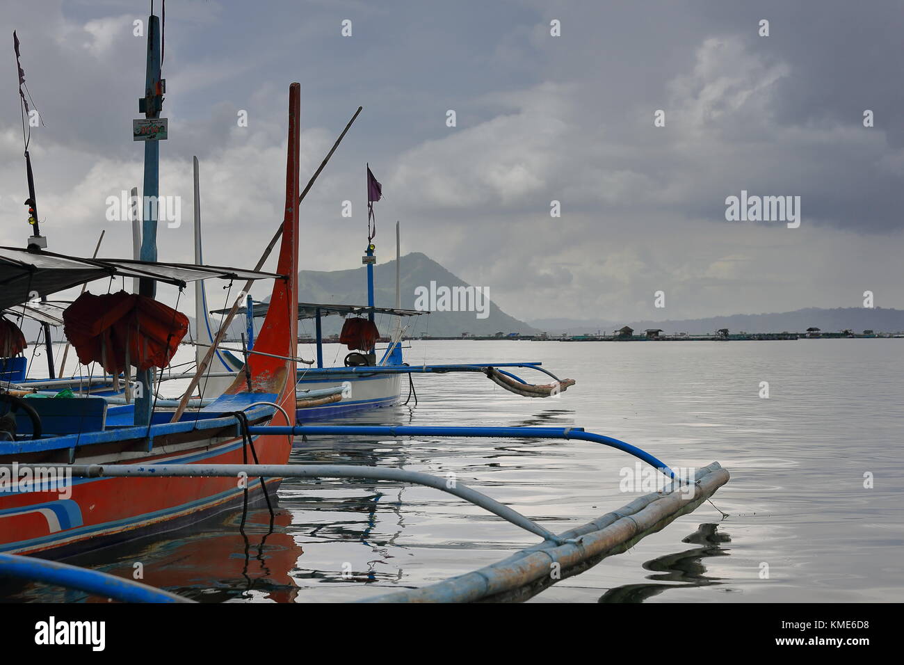 Amarré à l'embarcadère des bateaux-pompe en pirogues à caldera taal lake sous ciel nuageux en attente de passagers touristiques pour les transporter à l'intérieur du volcan Taal Banque D'Images