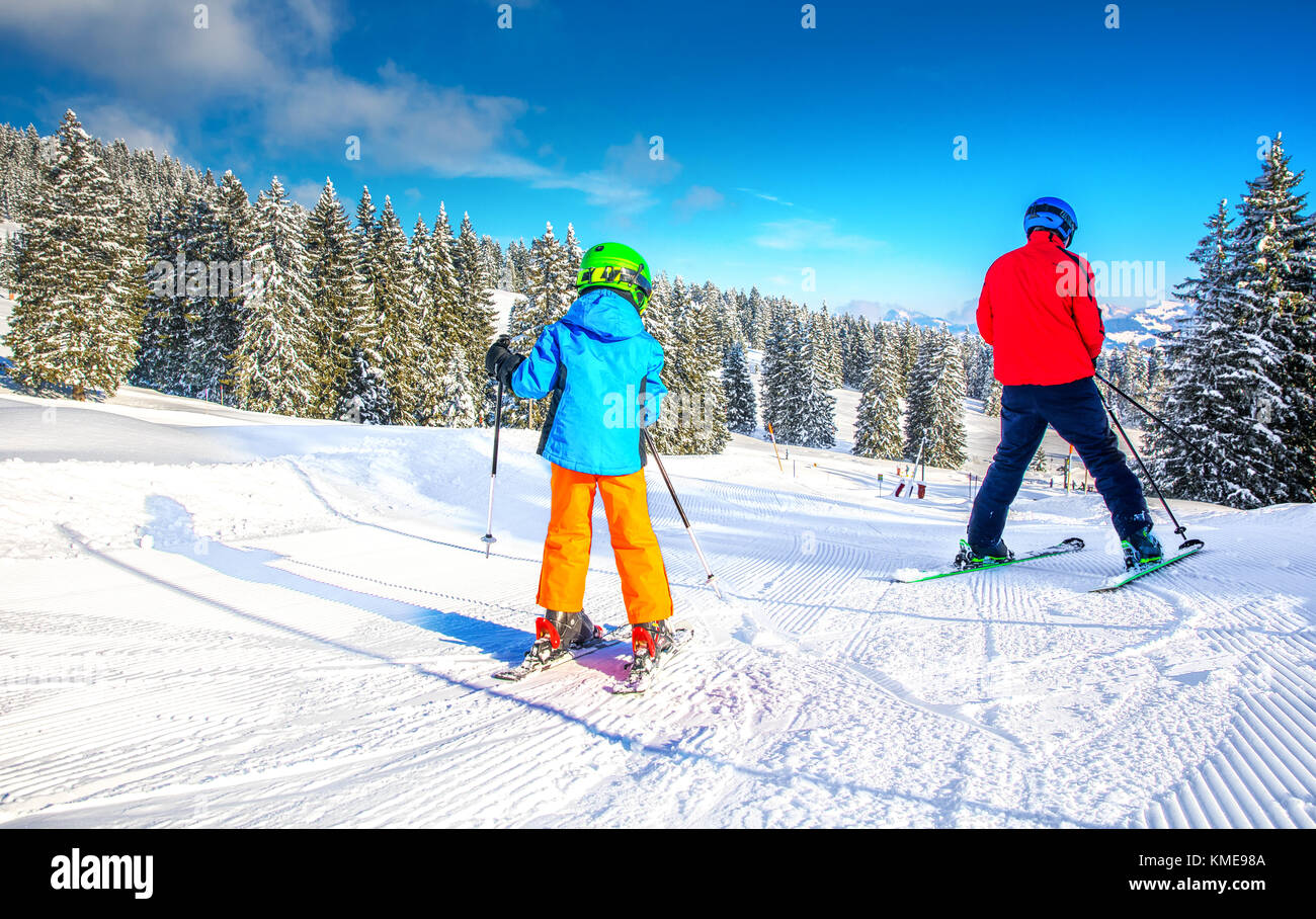 Heureux petit garçon avec son père sur le ski ski dans les Alpes. Banque D'Images