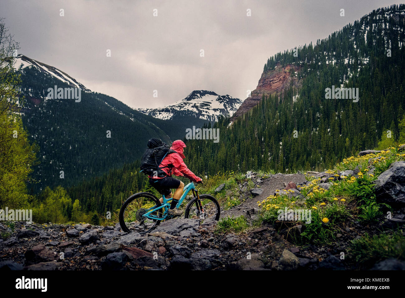 Femme motard de montagne dans un paysage pittoresque fait le chemin des lacs de glace sous la pluie, États-Unis Banque D'Images