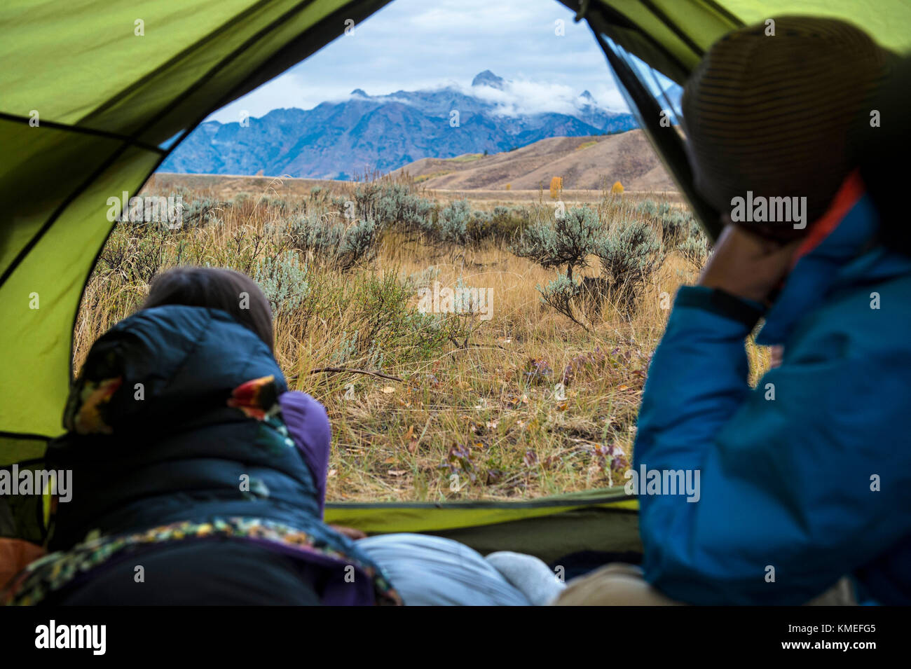 Camping couple looking at vue des montagnes à l'extérieur tente,Jackson,Wyoming, USA Banque D'Images