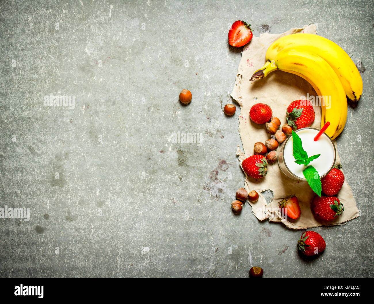 Dessert avec du lait de noix, de baies et de bananes. sur la table de pierre. Banque D'Images