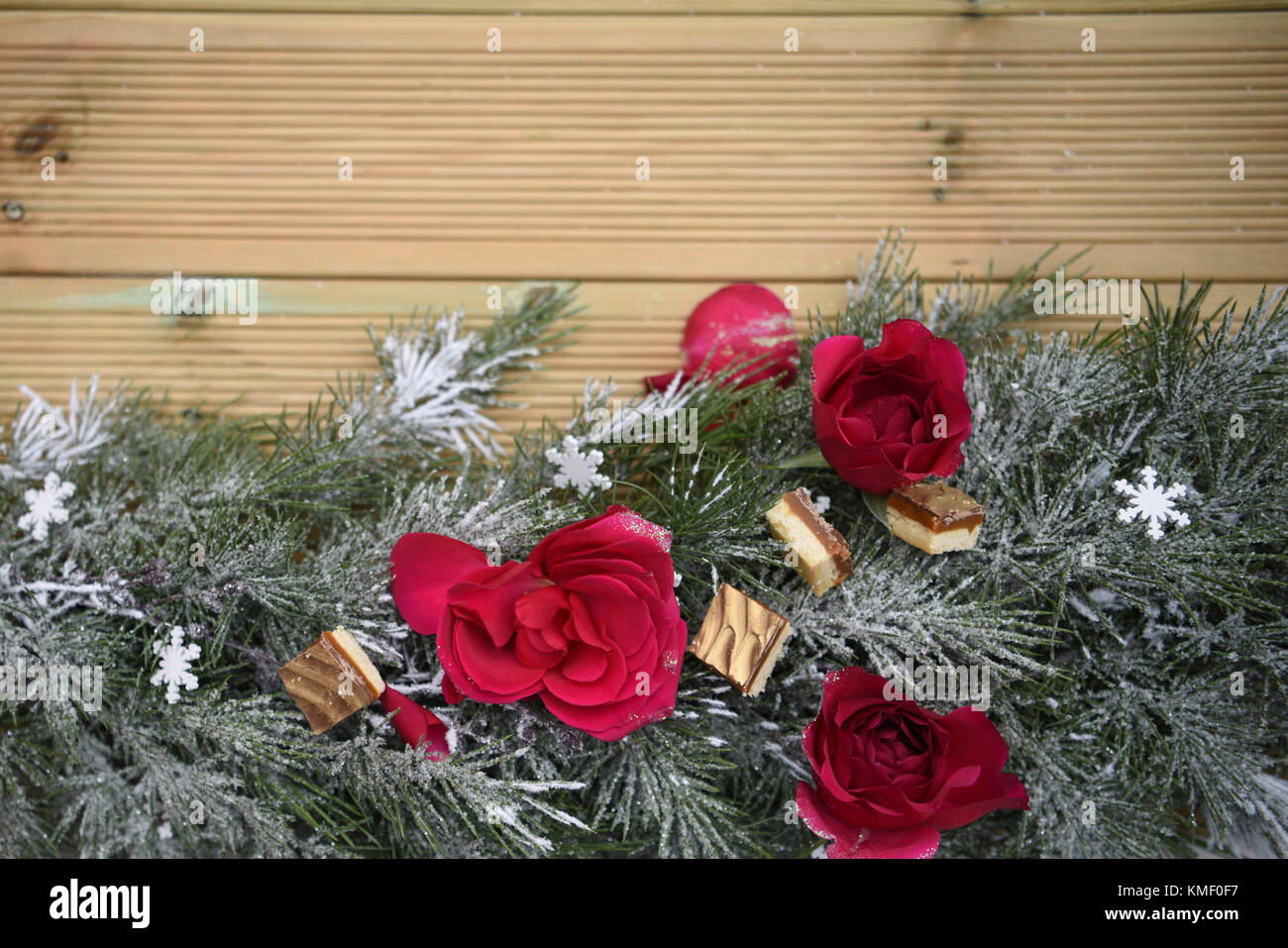 Belle photographie image romantique de noël avec guirlande de roses rouges fraîches et de décoration avec des chocolats de luxe en bois et l'arrière-plan de l'espace de copie Banque D'Images