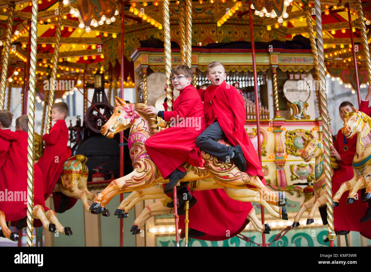 Les choristes à partir de la cathédrale d'Ely dans le Cambridgeshire obtenir un cadeau de Noël qu'ils get a free ride sur une 107 ans carousel le vendredi après-midi du 17 novembre que la cathédrale est titulaire d'un marché de noël. Les choristes de cathédrale d'Ely se défouler sur un carrousel traditionnel au marché de Noël de la ville cet après-midi (vendredi). Les choristes résidents portaient leurs soutanes rouges comme ils ont apprécié les forains ride à l'extérieur de la cathédrale du xiie siècle. le cadeau de Noël d'Ely et salon de l'alimentation est le plus grand de son genre dans le comté et espère attirer 15 000 visiteurs au cours des deux prochains jours. Banque D'Images