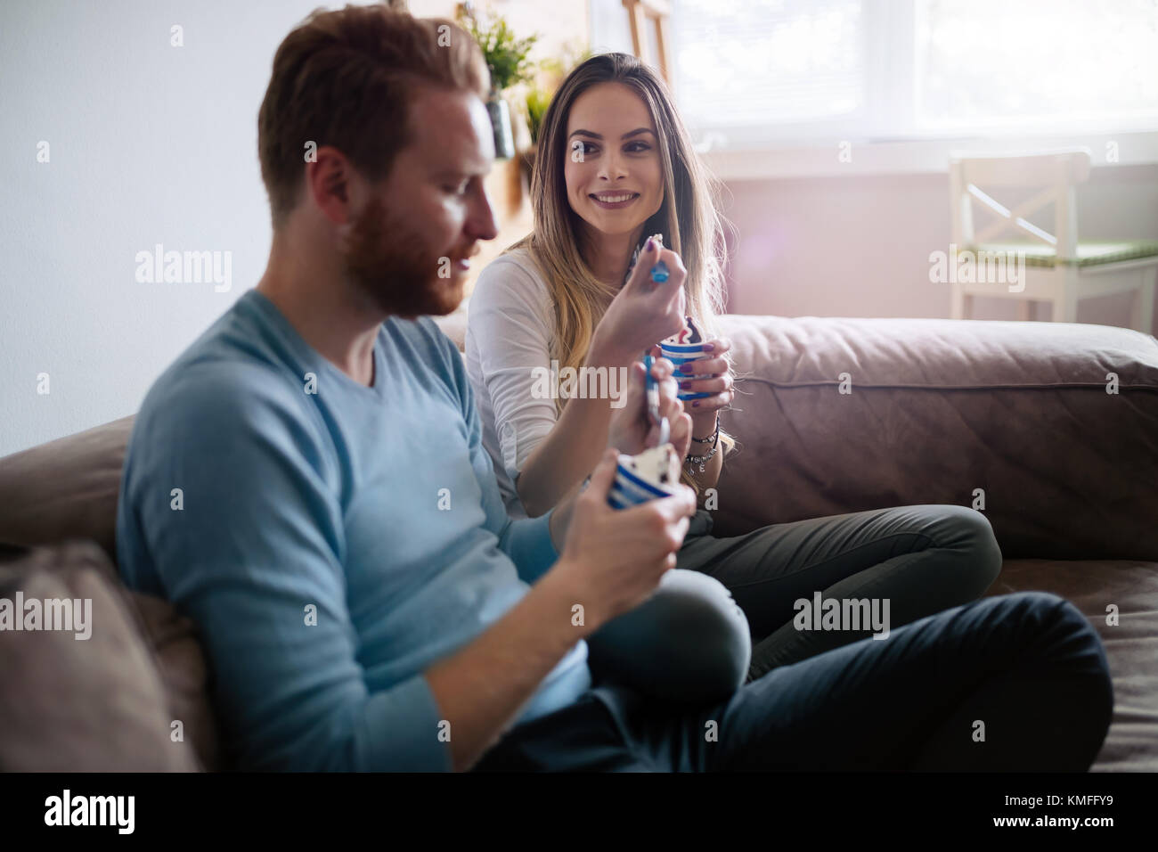 Romantic couple eating ice cream ensemble et regarder la télévision Banque D'Images