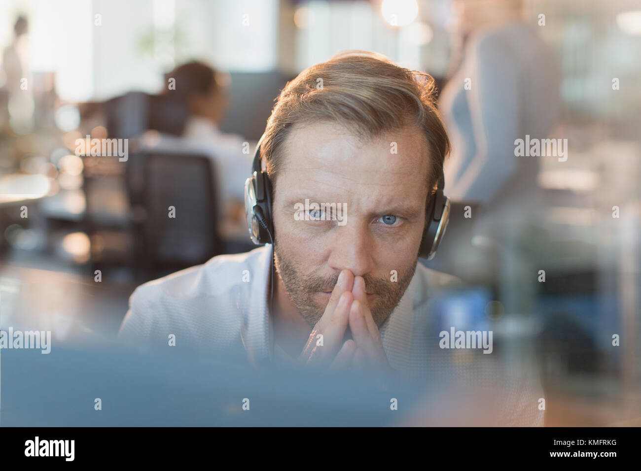 Serious businessman wearing headphones, travaillant à l'ordinateur Banque D'Images