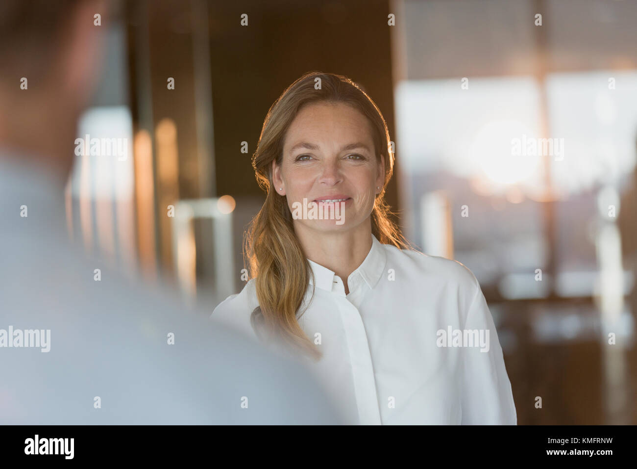 Confident businesswoman listening to in office Banque D'Images