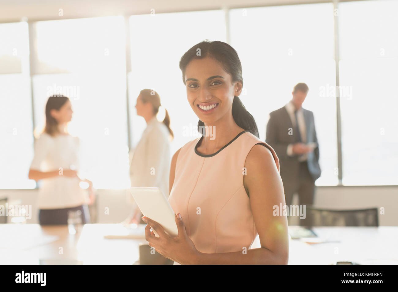 Portrait femme d'affaires souriante et confiante avec une tablette numérique dans la salle de conférence Banque D'Images