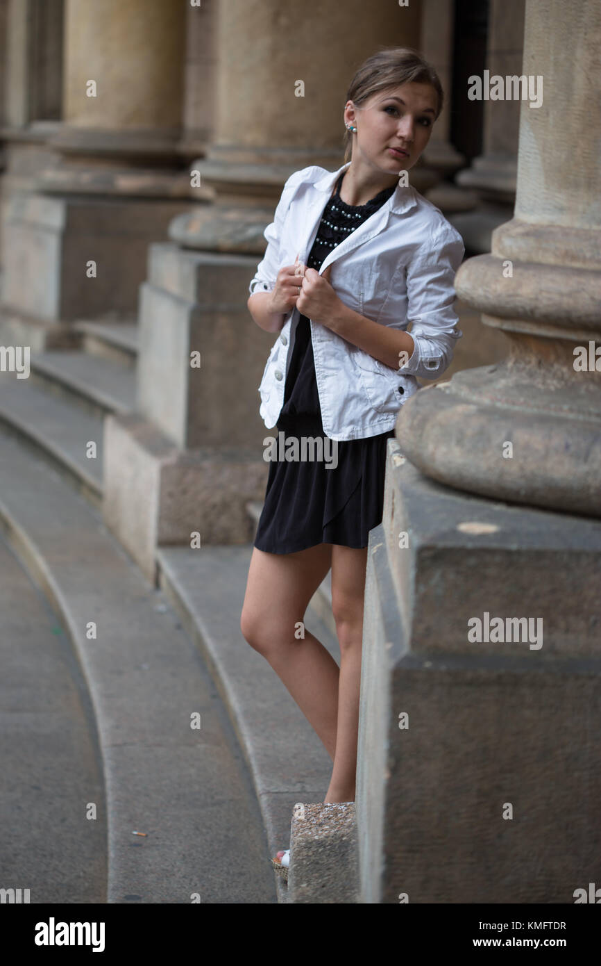 Portrait d'une jeune femme portant une veste blanche et robe noire avec du  blanc sur la plate-forme chaussures colonnes historique architecture fond  Photo Stock - Alamy