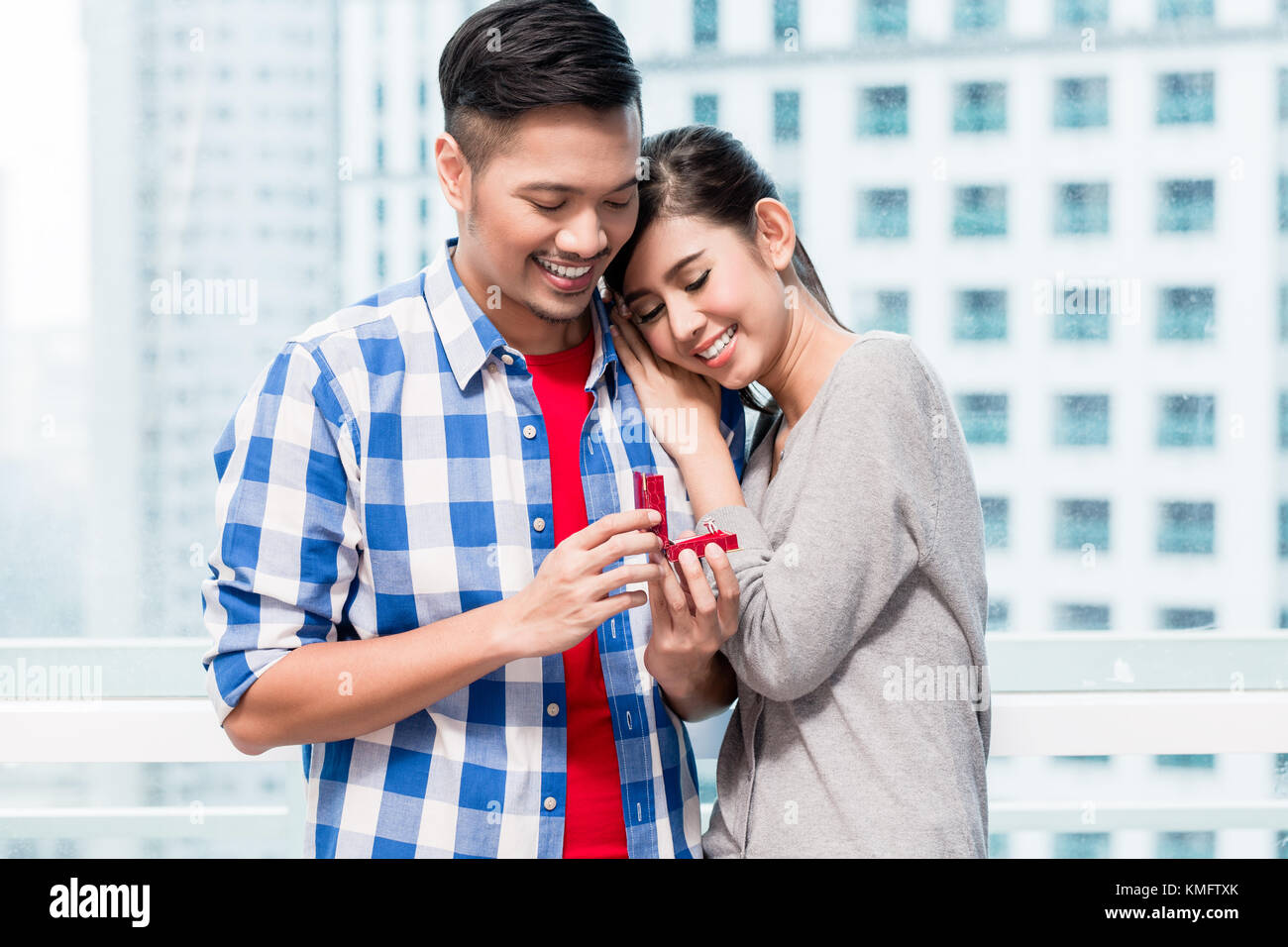 Young indonesian man fait de proposition à sa petite amie tout le jour du déménagement dans appartement neuf Banque D'Images