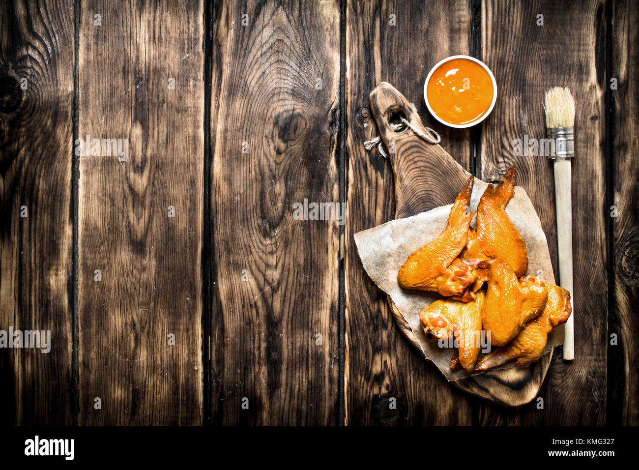 Ailes de poulet fumé avec sauce. sur une table en bois. Banque D'Images