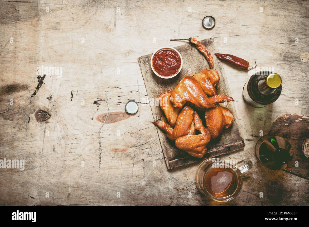 Ailes de poulet fumé à la bière et sauce. sur une table en bois. Banque D'Images