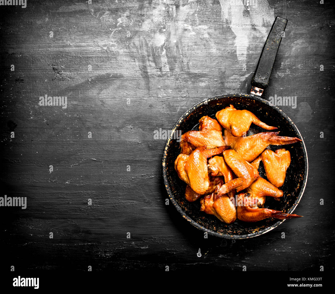 Ailes de poulet fumé à la casserole. sur noir tableau. Banque D'Images
