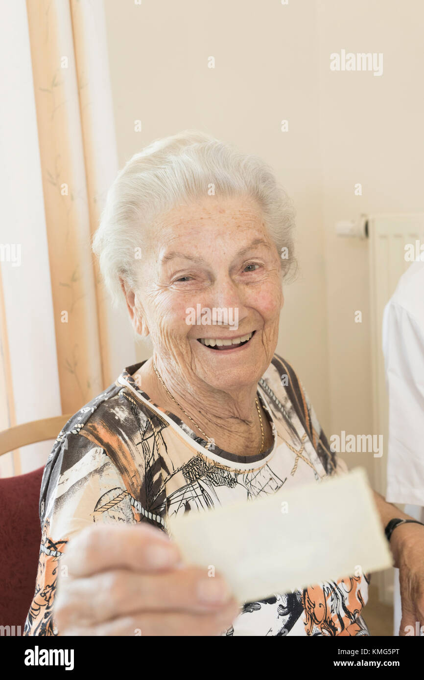 Senior woman watching photo dans rest home Banque D'Images