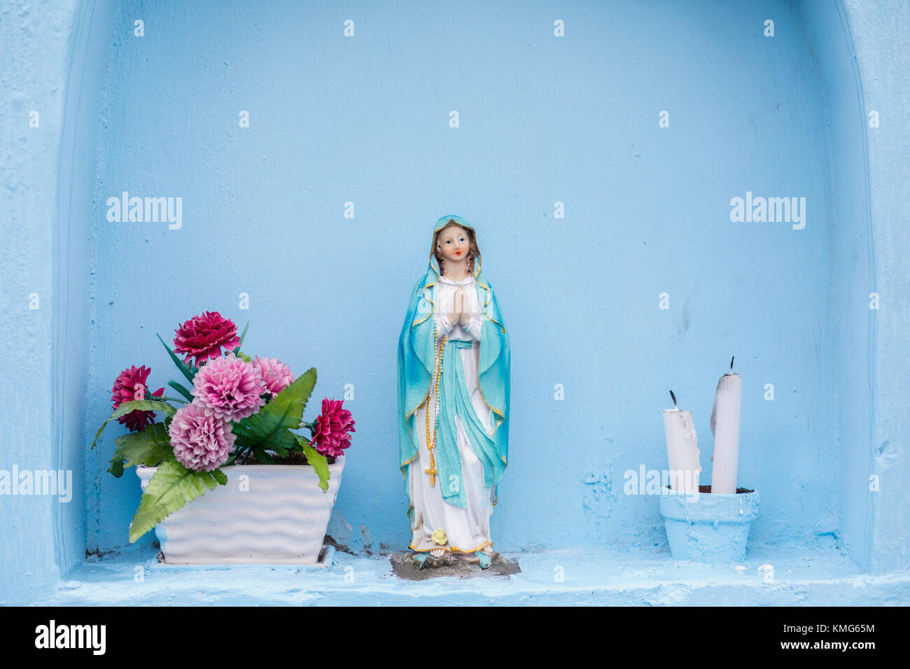 Statue de Maria avec fleurs et bougies Banque D'Images