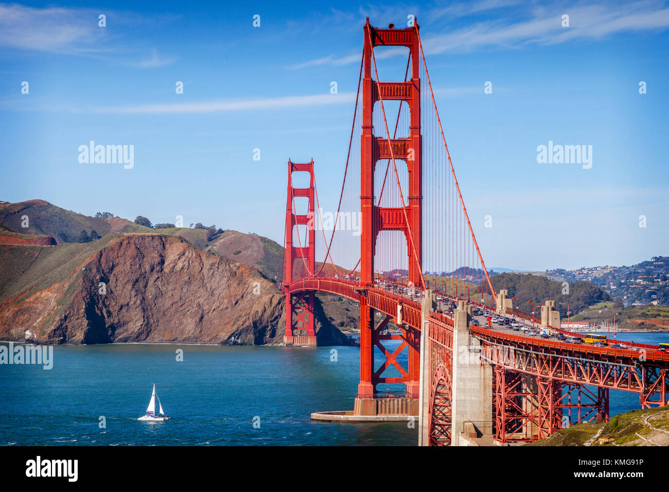 Le golden gate bridge, San Francisco, à la fin de soleil du soir, avec un catamaran sur le point de passer en dessous dans la baie.. Banque D'Images