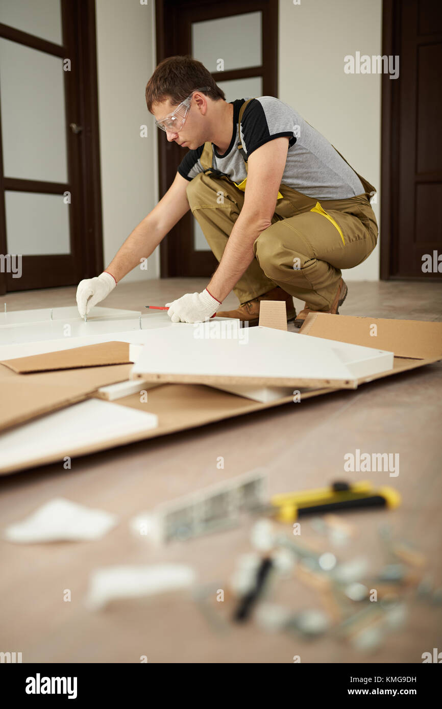 Homme menuisier montage de meubles à assembler. chambre thème meubles Banque D'Images
