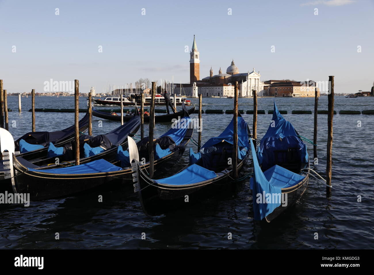 Venise, Italie : les gondoles sont amarrés le long de la Riva degli Schiavoni, près de la Piazza San Marco avec l'église de San Giorgio Maggiore vu dans la distance. Banque D'Images