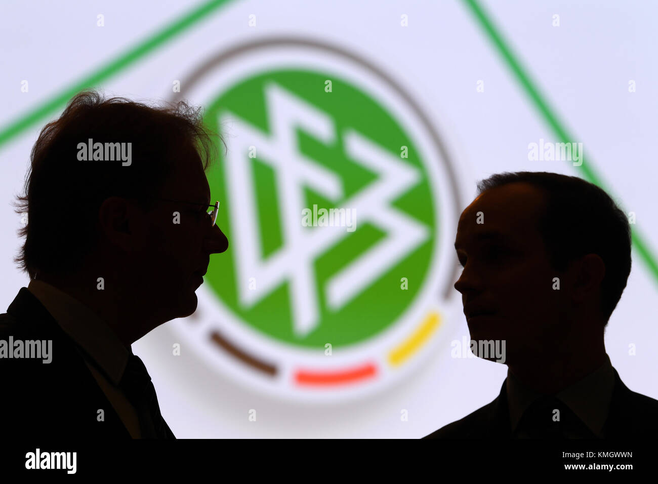 Deux délégués prennent la parole devant le logo de la DFB lors de la conférence fédérale extraordinaire de la Fédération allemande de football ('Deutscher Fussball-Bund, DFB') à Francfort-sur-le-main, Allemagne, le 8 décembre 2017. Les délégués veulent faire place à des changements importants au sein de la plus grande association sportive du monde. Photo : Arne Dedert/dpa Banque D'Images