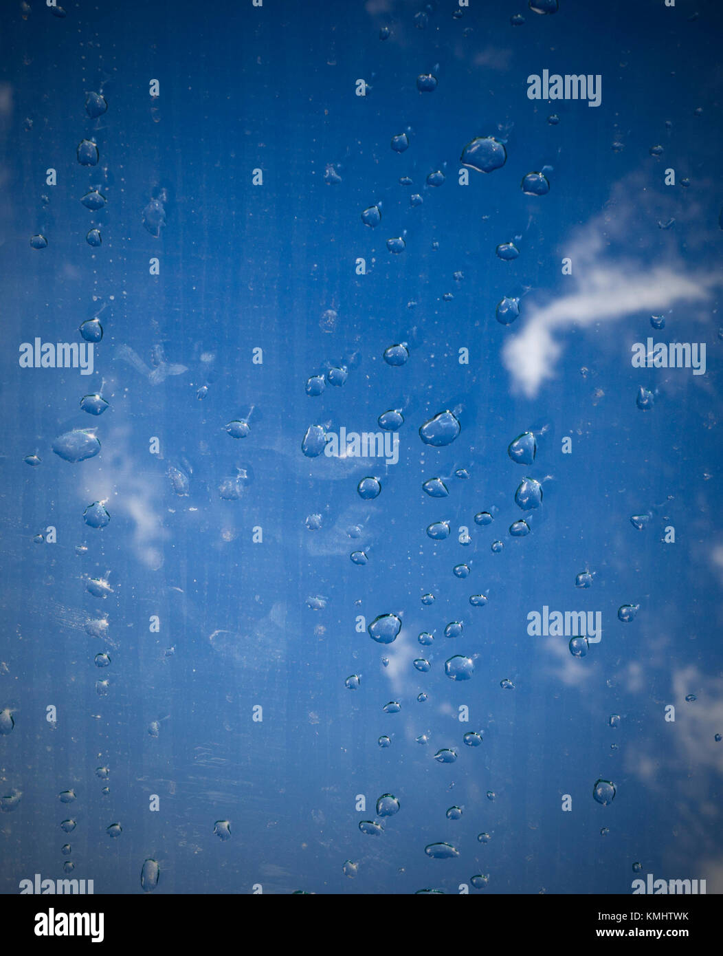 Gouttes d'eau sur le verre sous le ciel. La texture, l'arrière-plan. Banque D'Images