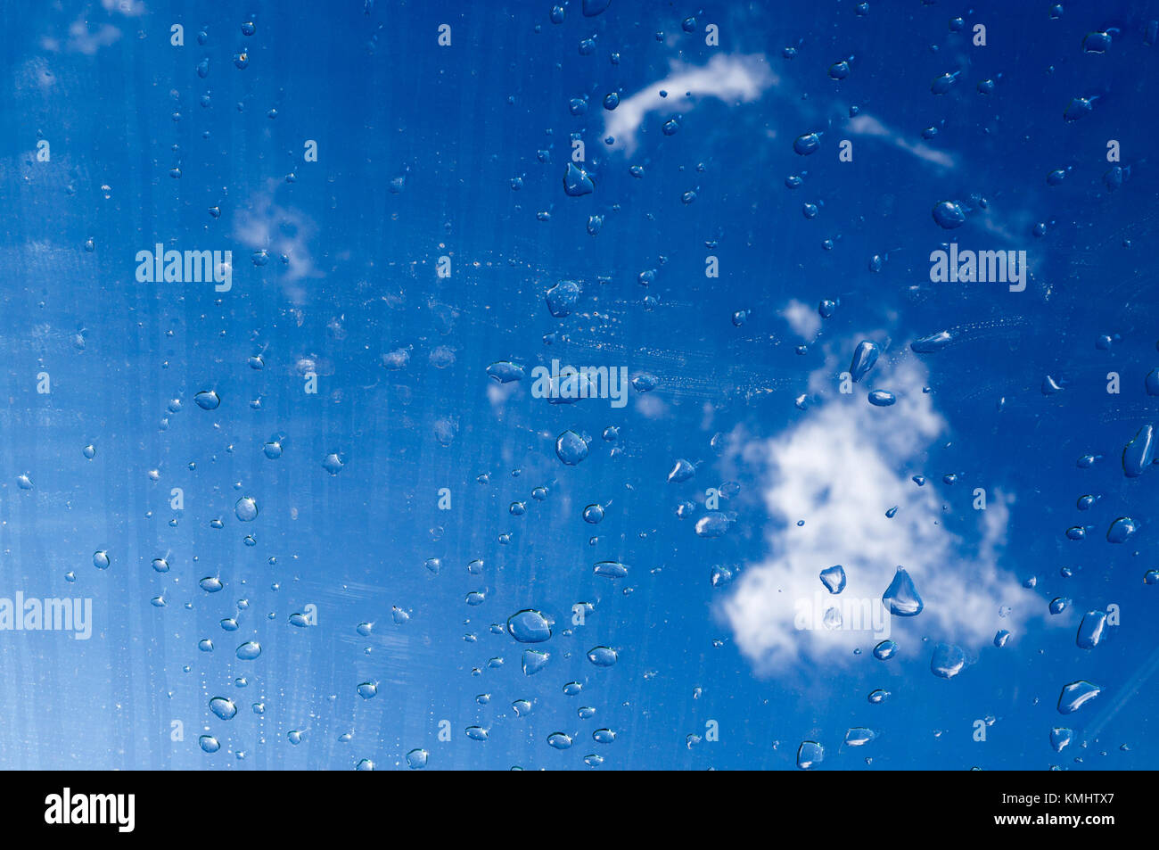 Gouttes d'eau sur le verre sous le ciel. La texture, l'arrière-plan. Banque D'Images