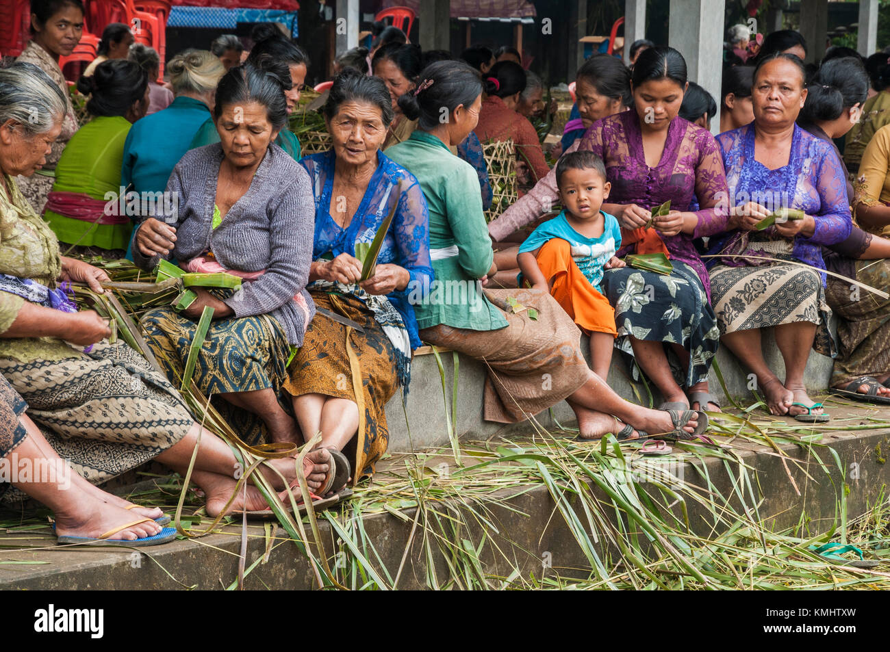 Femmes dans le village de Tegalalang, fabriquant des paniers pour porter des offrandes lors d'un rituel traditionnel de crémation communautaire, Tegalalang, Gianyar, Bali, Indonesi Banque D'Images