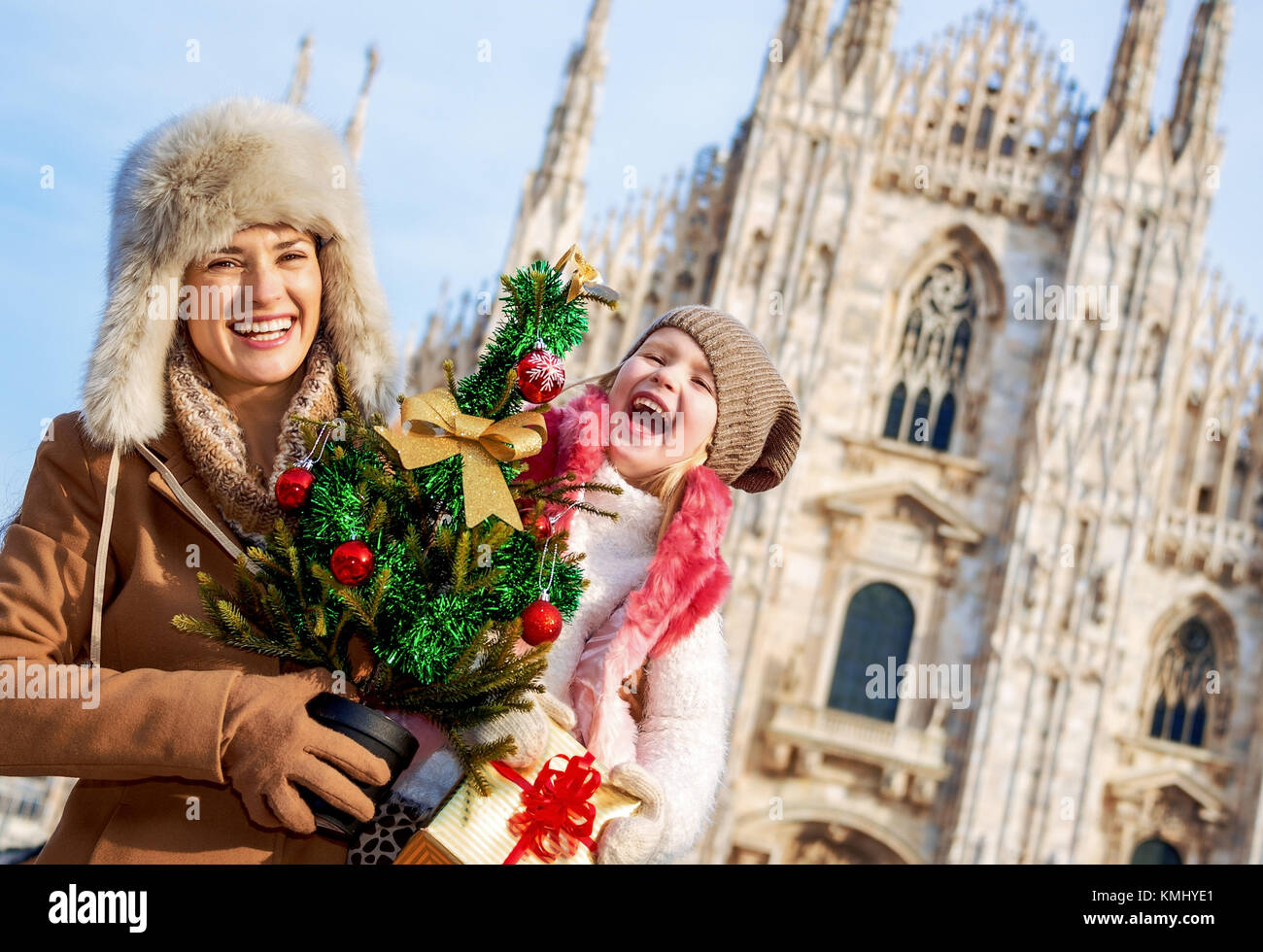 Fun Noël famille voyage à Milan, Italie. cheerful young mother and daughter  les voyageurs avec arbre de Noël et cadeau dans l'avant du Duomo de Milan  Photo Stock - Alamy