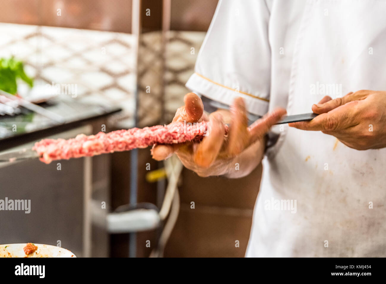 Man main préparer de délicieux plats turcs traditionnels shish kebab brochette faite d'agneau foie. Banque D'Images
