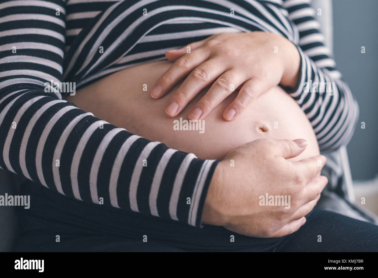 L'amour doux femelle enceinte avec les mains sur son ventre dans le troisième trimestre de la grossesse s'attendant bébé nouveau-né Banque D'Images