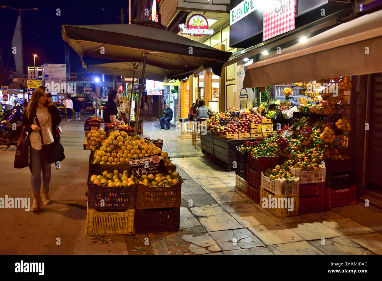Scène de rue la nuit au Pirée, banlieue d'Athènes, avec les fruits et légumes locaux sur la rue principale d'affichage Banque D'Images