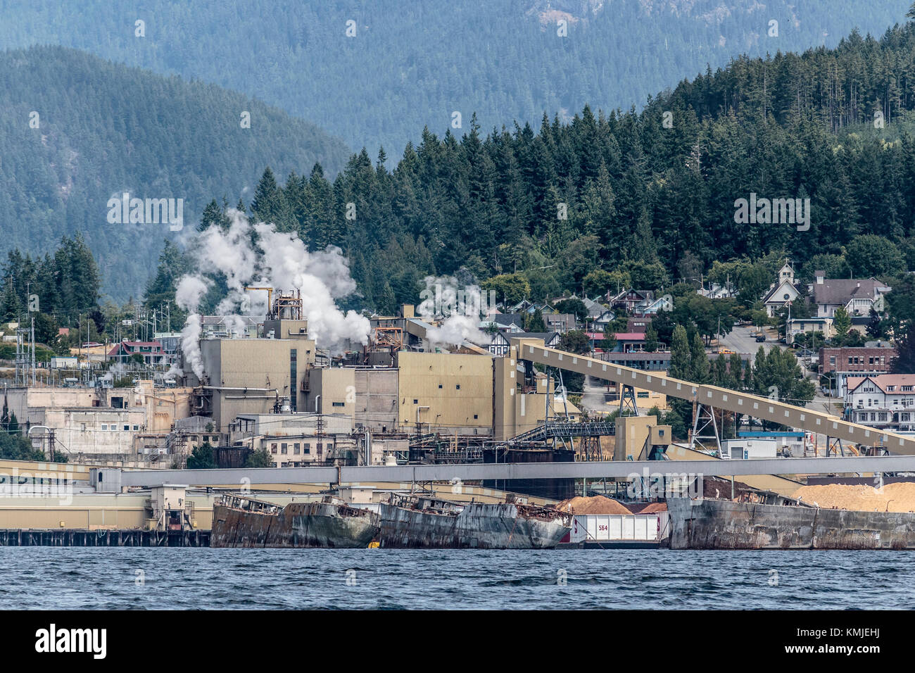 Les huttes de béton de la Seconde Guerre mondiale forment un brise-lames flottant devant le moulin à papier (maintenant fermé) et le site historique de la ville de Powell River, en Colombie-Britannique (2017). Banque D'Images
