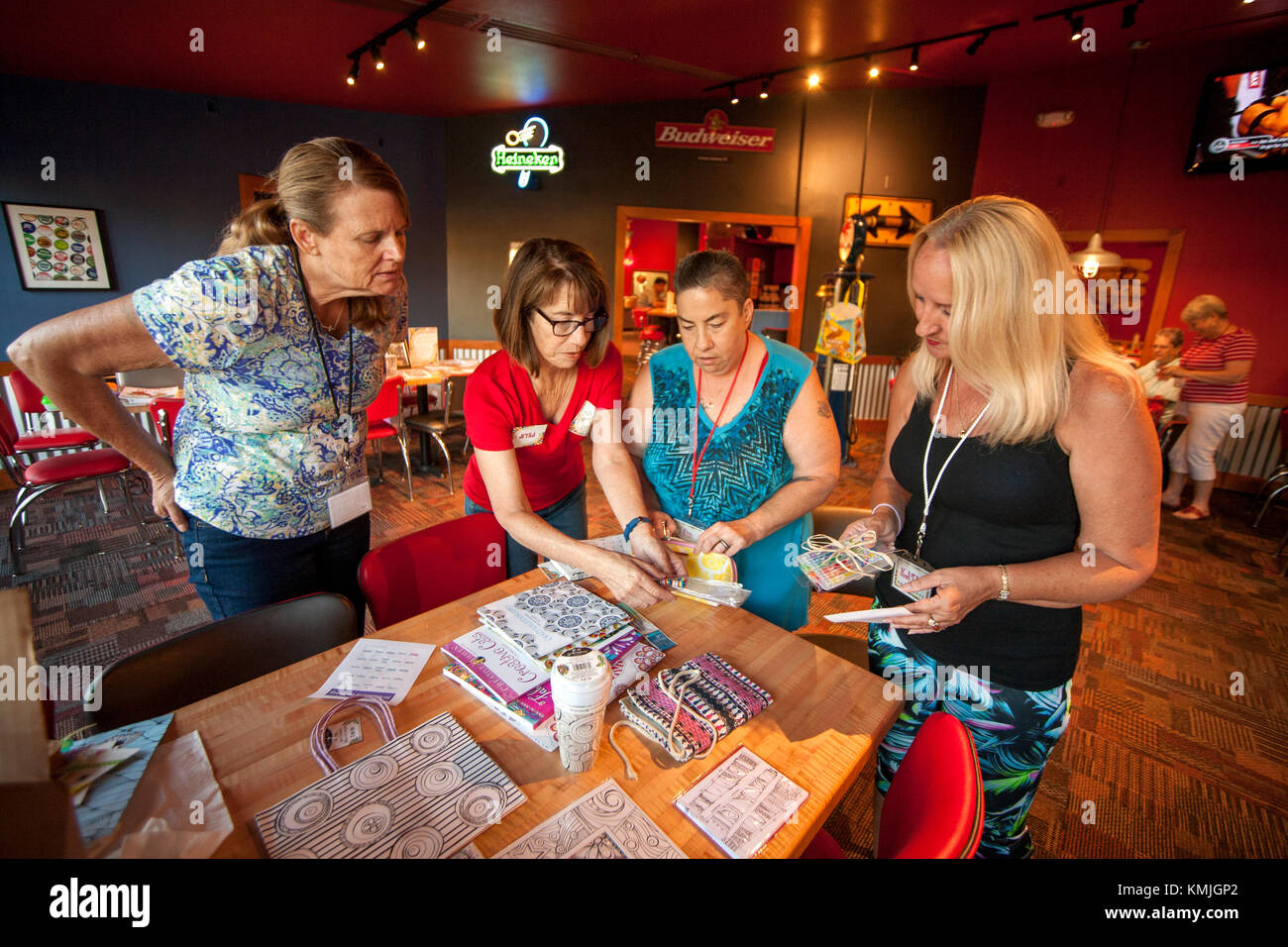 Les femmes d'âges différents se rassemblent à un livre de coloriage adultes atelier d'un lake forest, ca, restaurant salle multifonctions et sélectionnez un des prix offerts par bingo. simultanée Banque D'Images