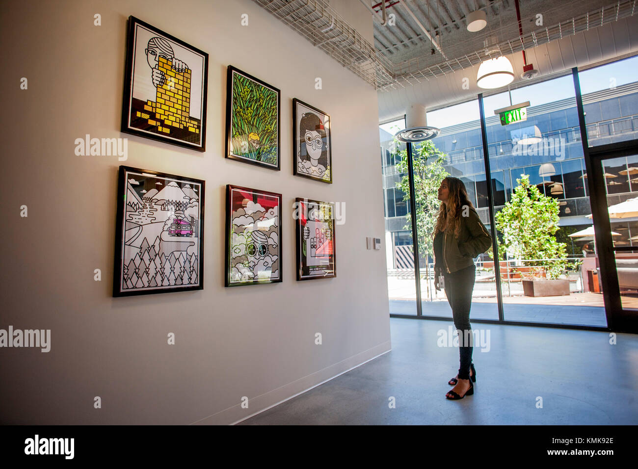 Une jeune femme adulte parcourt la collection d'art de la cars shoe company siège social à Costa Mesa, ca. Remarque cour aménagée en arrière-plan. Banque D'Images